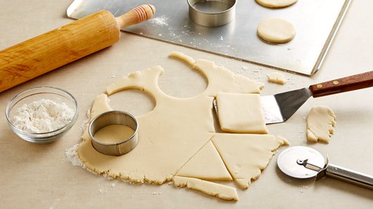 On floured surface, roll dough to 1/4-inch thickness. Cut with floured 2 1/2- to 3 1/2-inch shape cookie cutters (round, square, triangle). On ungreased cookie sheets, place cutouts 2 inches apart. Reroll dough and cut additional cookies.