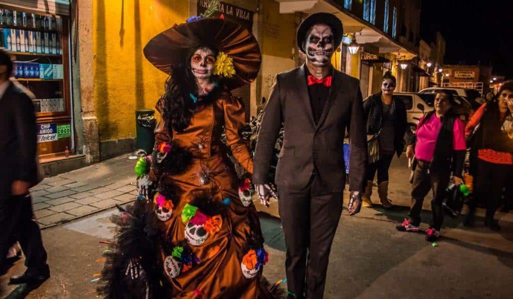 a couple wearing Halloween costumes with skulls