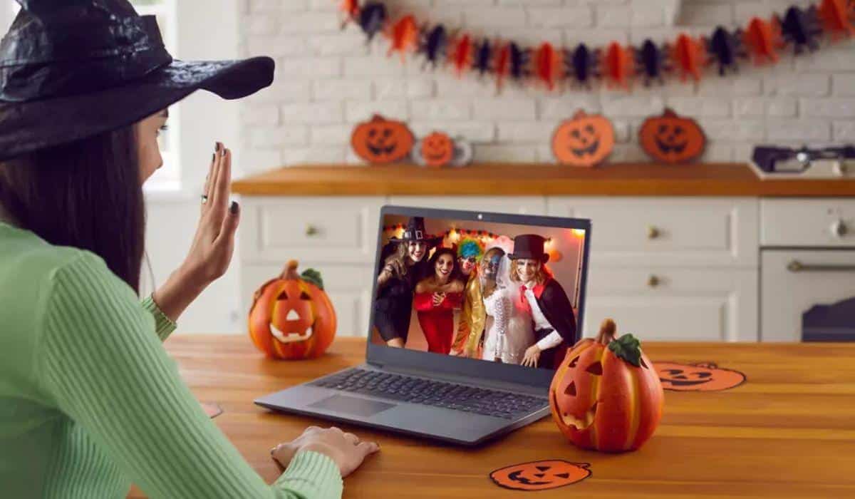 a woman video calls friends on her laptop during Halloween