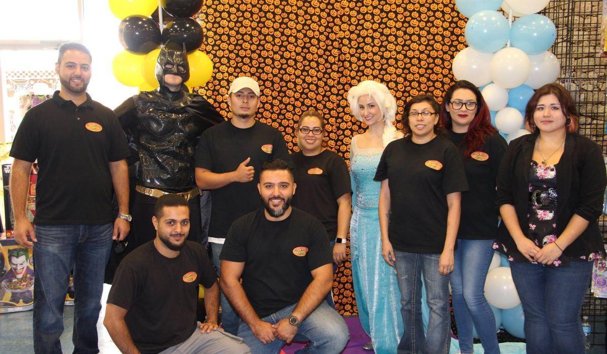 two people in batman and Elsa costumes taking a group photo