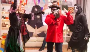 Costumed friends enjoying halloween party games with festive decorations and lively atmosphere for a spooky celebration.